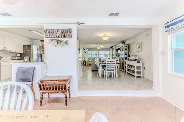 dining room featuring ceiling fan, light tile patterned floors, and baseboards