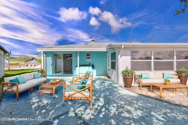 rear view of property with an outdoor hangout area, a patio area, and stucco siding