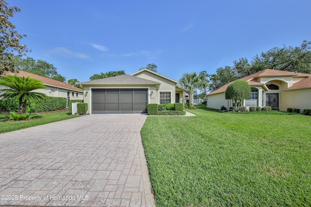 ranch-style house with decorative driveway, a front yard, a garage, and stucco siding