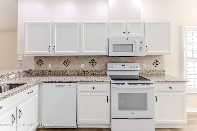 kitchen with white appliances, white cabinets, and decorative backsplash