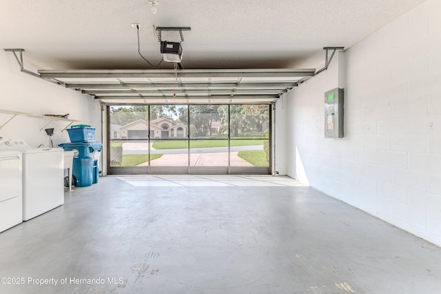 garage featuring independent washer and dryer, electric panel, a garage door opener, and concrete block wall