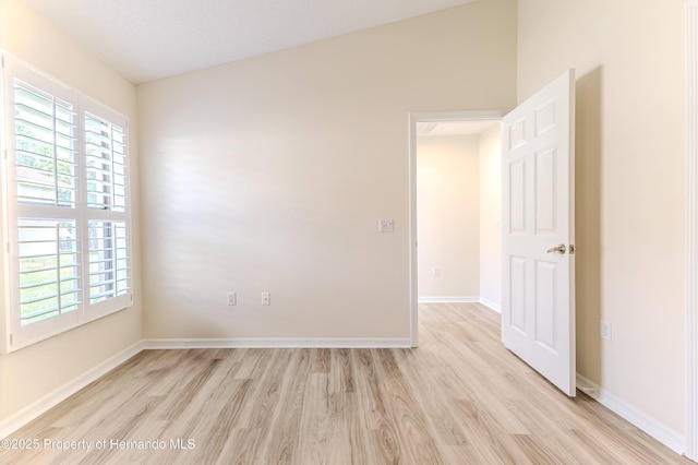 spare room with light wood finished floors and baseboards