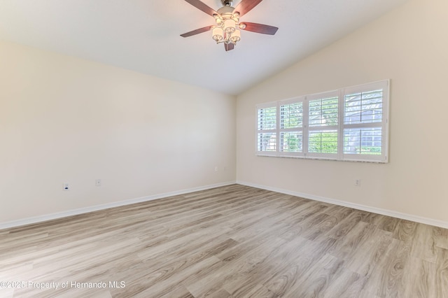 spare room with light wood finished floors, lofted ceiling, a ceiling fan, and baseboards