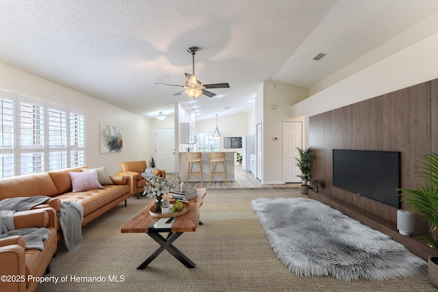living area featuring lofted ceiling and ceiling fan