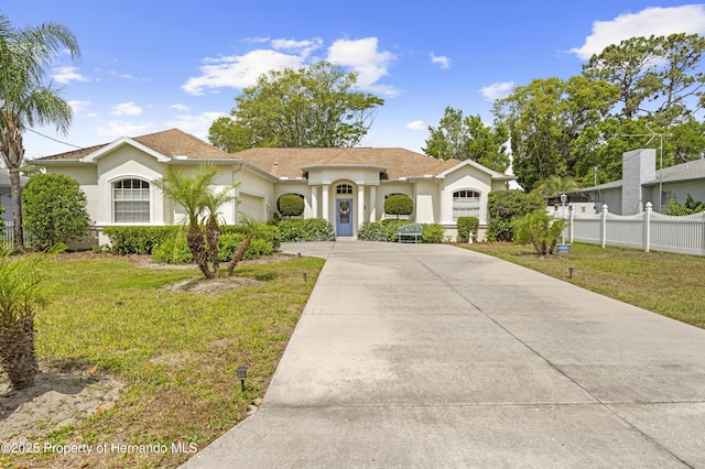 mediterranean / spanish home with an attached garage, driveway, and stucco siding