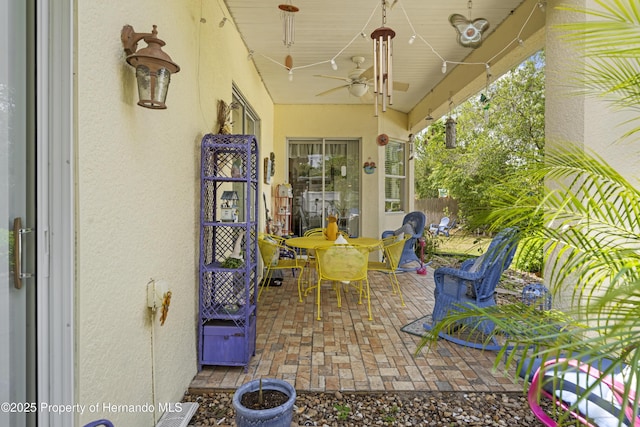 view of patio featuring a ceiling fan, outdoor dining space, and fence