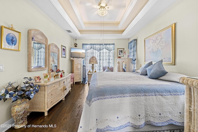 bedroom featuring dark wood-type flooring, crown molding, and a raised ceiling