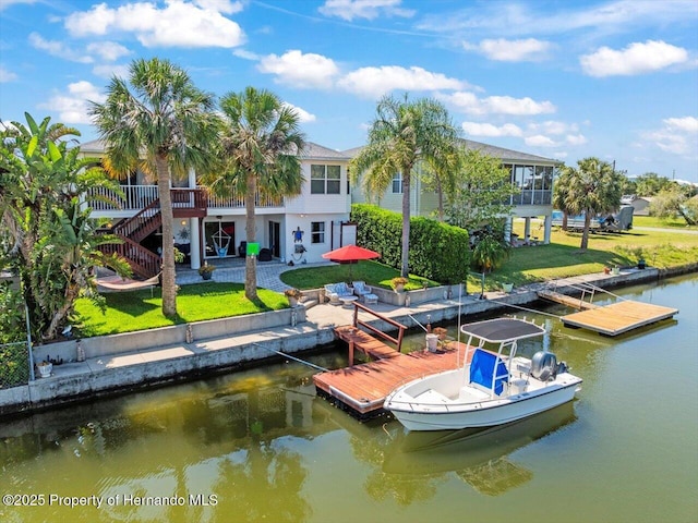 dock area featuring a water view, a yard, and stairway
