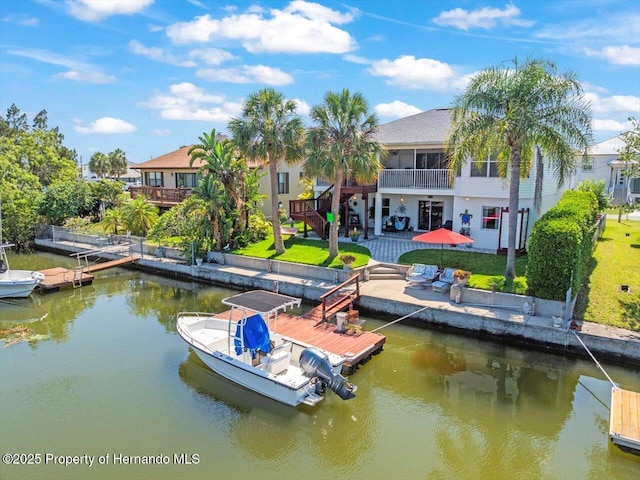 dock area featuring a water view, a patio area, and a lawn