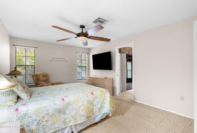 bedroom with multiple windows, light carpet, a ceiling fan, and baseboards