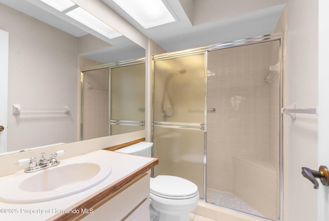 bathroom featuring a stall shower, toilet, and vanity