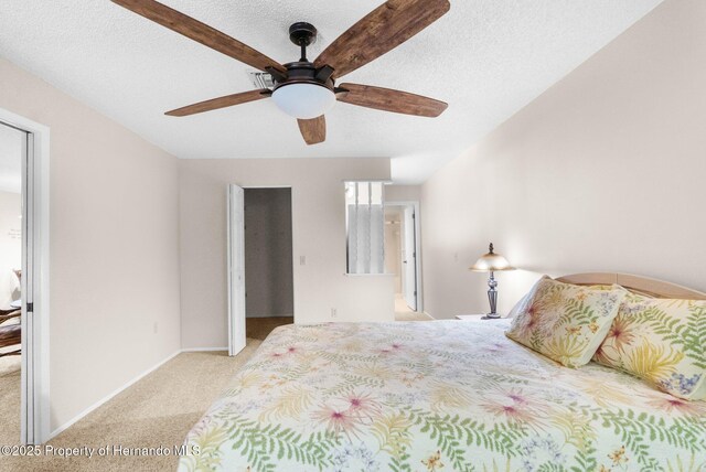 bedroom featuring carpet, a textured ceiling, baseboards, and a ceiling fan