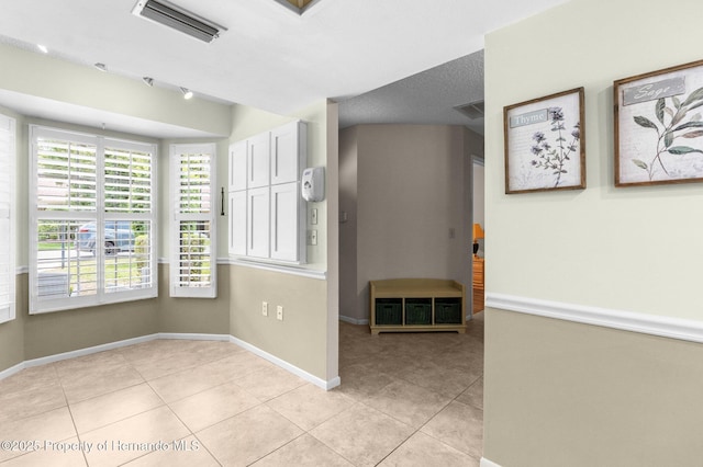 unfurnished room featuring light tile patterned floors and baseboards