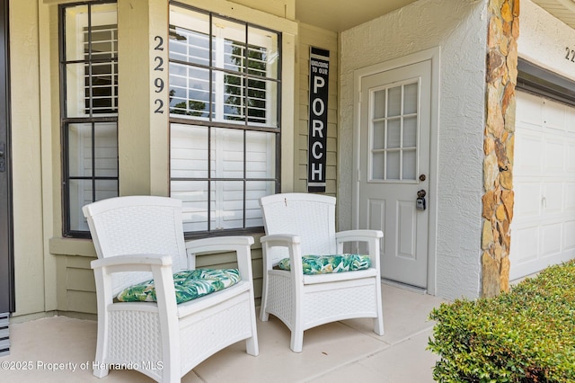 view of exterior entry with a porch and a garage