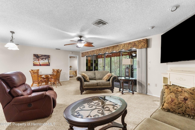 carpeted living area featuring baseboards, a ceiling fan, and a textured ceiling