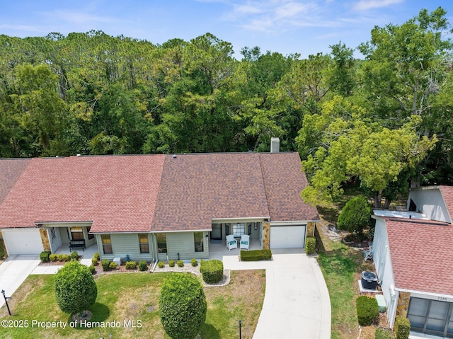 aerial view of property and surrounding area with a heavily wooded area