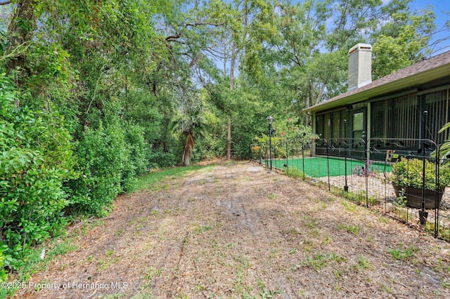 view of yard with fence and a sunroom