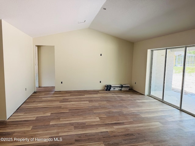 11406 Labrador Duck Rd, Weeki Wachee, FL 34613 - unfurnished living room featuring vaulted ceiling and wood finished floors