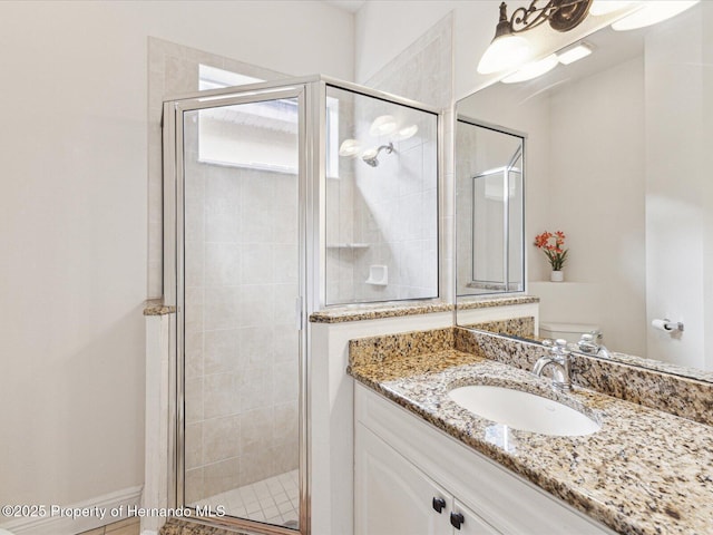 full bathroom featuring a shower stall, vanity, and toilet