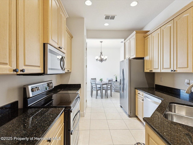 kitchen featuring appliances with stainless steel finishes, light brown cabinets, a sink, and recessed lighting