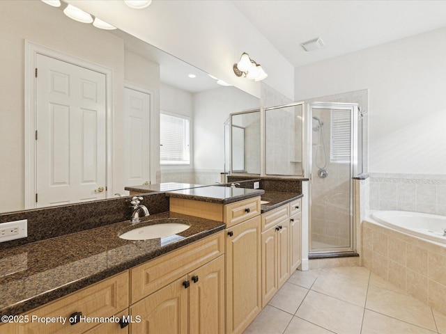 full bathroom featuring tile patterned flooring, a shower stall, a garden tub, and vanity