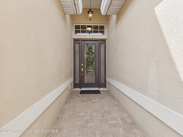 doorway to property featuring stucco siding