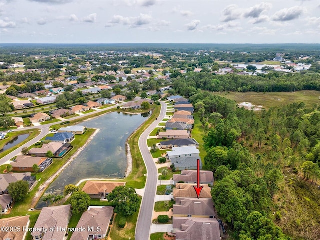 aerial view of property and surrounding area with a large body of water and nearby suburban area