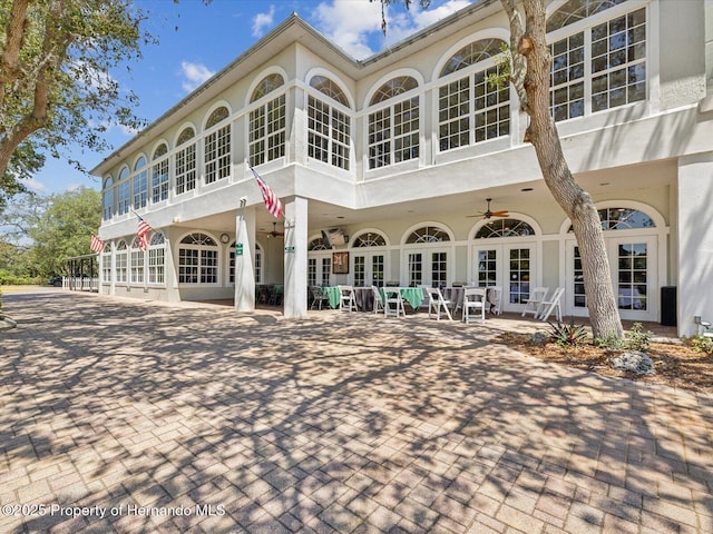 rear view of property with french doors, a patio, and stucco siding
