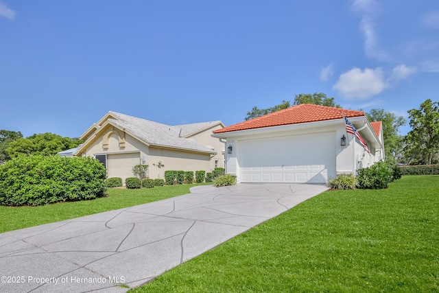 mediterranean / spanish-style house featuring a front yard, stucco siding, a tiled roof, and concrete driveway