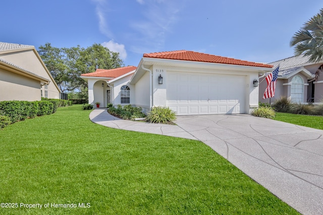 mediterranean / spanish house featuring a tiled roof, an attached garage, a front lawn, concrete driveway, and stucco siding