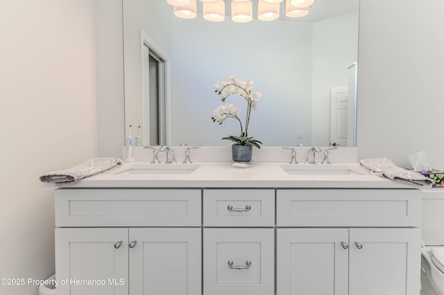 bathroom with toilet and double vanity