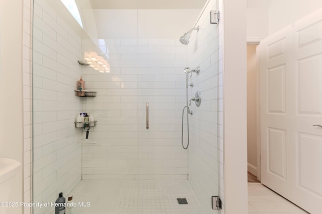 full bath featuring a shower stall, toilet, and tile patterned floors