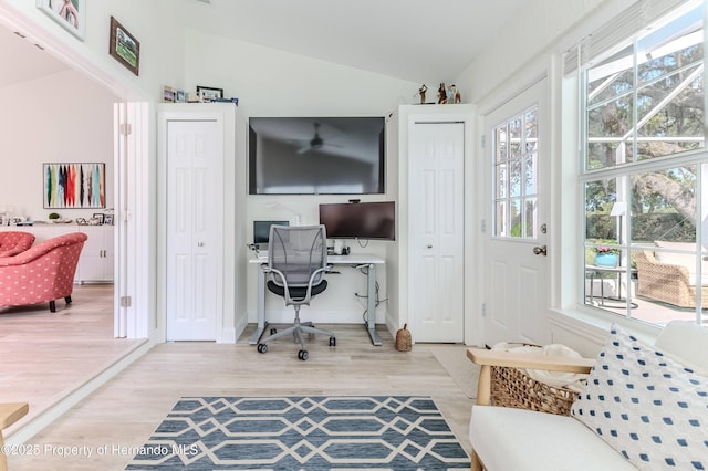 office area with vaulted ceiling, light wood-style flooring, and baseboards