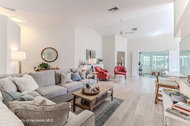 living area with light wood finished floors, ceiling fan, and high vaulted ceiling