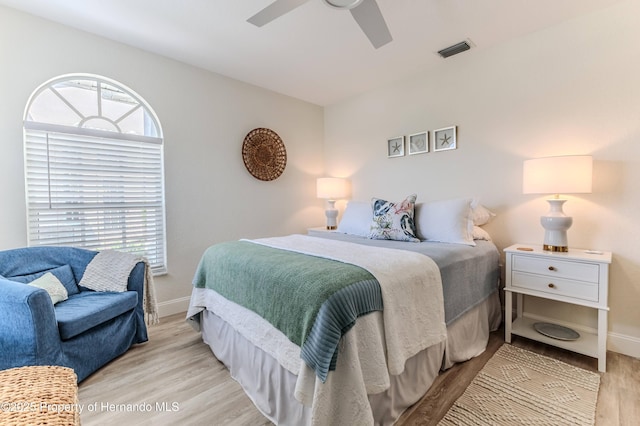 bedroom featuring wood finished floors, multiple windows, and baseboards