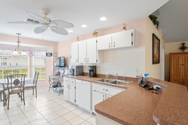12271 House Finch Rd, Weeki Wachee, FL 34614 - kitchen with dishwasher, a sink, ceiling fan, backsplash, and white cabinets