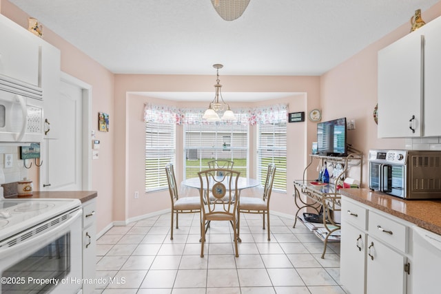 12271 House Finch Rd, Weeki Wachee, FL 34614 - dining room with baseboards and light tile patterned flooring