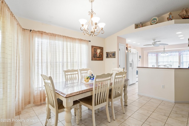 12271 House Finch Rd, Weeki Wachee, FL 34614 - dining area with a chandelier, vaulted ceiling, light tile patterned floors, a ceiling fan, and baseboards