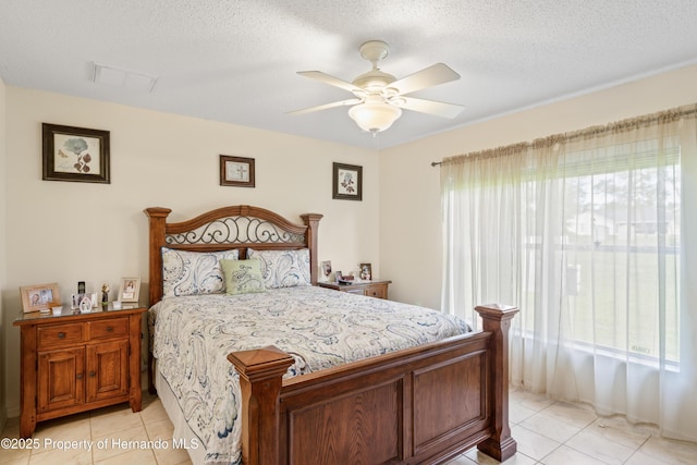 12271 House Finch Rd, Weeki Wachee, FL 34614 - bedroom with light tile patterned flooring, ceiling fan, and a textured ceiling