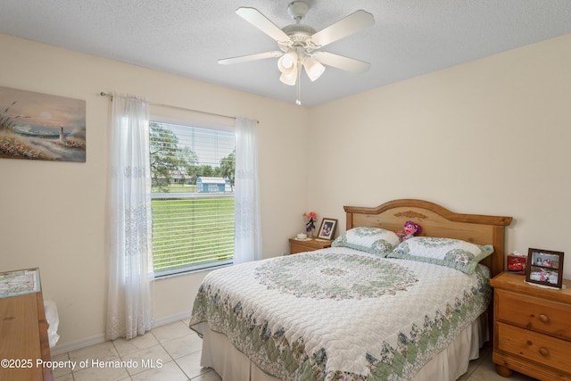 12271 House Finch Rd, Weeki Wachee, FL 34614 - bedroom featuring baseboards, a ceiling fan, light tile patterned floors, and a textured ceiling