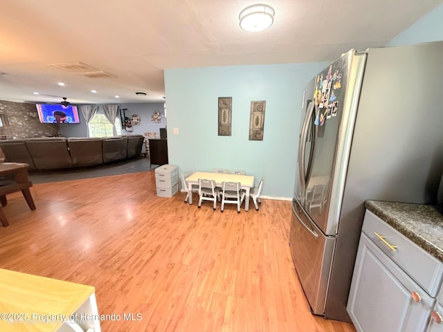 11080 Jackdaw Rd, Weeki Wachee, FL 34613 - kitchen with freestanding refrigerator, light wood-style floors, dark countertops, and open floor plan