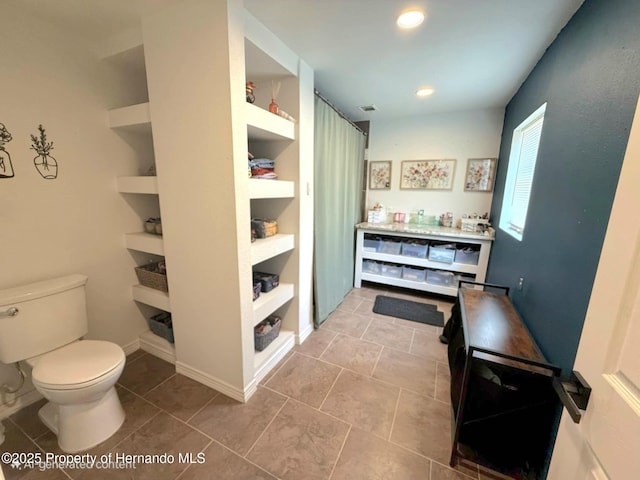 11080 Jackdaw Rd, Weeki Wachee, FL 34613 - bathroom with toilet, built in shelves, tile patterned floors, vanity, and recessed lighting