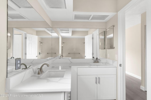 full bath with a shower, double vanity, baseboards, and wood finished floors