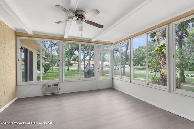 unfurnished sunroom featuring beam ceiling, ceiling fan, and a wall mounted air conditioner