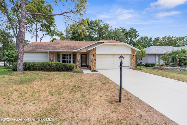 single story home with a garage, a front yard, concrete driveway, and stone siding