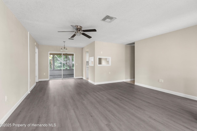 unfurnished living room with ceiling fan, dark wood finished floors, baseboards, a textured ceiling, and a chandelier