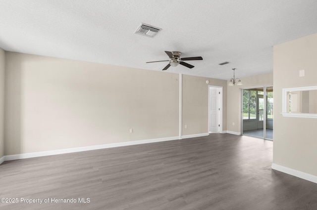 spare room featuring ceiling fan, wood finished floors, a chandelier, baseboards, and a textured ceiling
