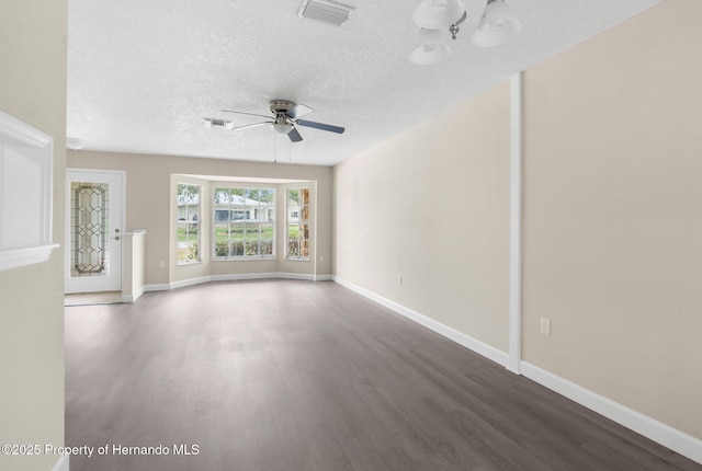 unfurnished living room with wood finished floors, ceiling fan, baseboards, and a textured ceiling
