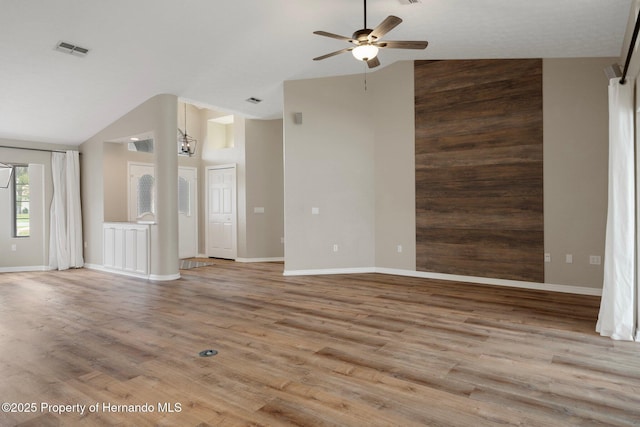 unfurnished living room featuring ceiling fan, high vaulted ceiling, wood finished floors, and baseboards