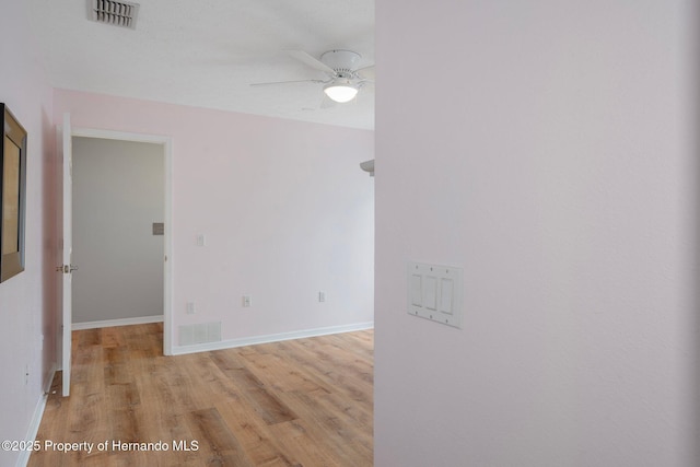spare room featuring a ceiling fan, wood finished floors, and baseboards